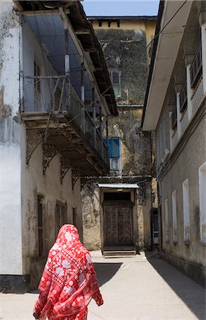 A woman in a colourful headscarf walking down a narrow street in Stone Town, Zanzibar, Tanzania, East Africa, Africa Stock Photo - Rights-Managed, Code: 841-02899910