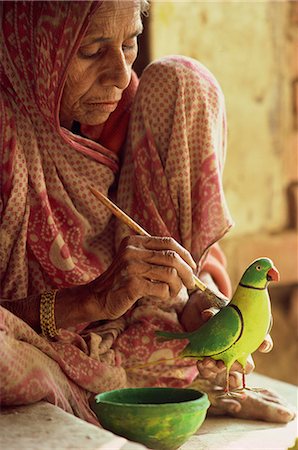 A woman paints a clay toy parrot, northern India, India, Asia Foto de stock - Con derechos protegidos, Código: 841-02900307