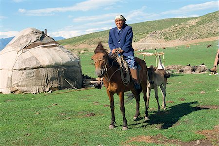 provincia di xinjiang - Kazak woman on horseback beside a yurt in the Altay mountains, north east Xinjiang, China, Asia Fotografie stock - Rights-Managed, Codice: 841-02901297