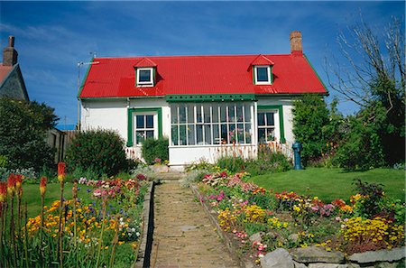 Flower beds line a brick path up to a typical private house, with bright red corrugated roof, in Stanley, capital of the Falkland Islands, South America Fotografie stock - Rights-Managed, Codice: 841-02901647