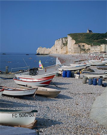 etretat - Small boats and people on the beach with cliffs in the background, at Etretat, on the coast of Haute Normandie, France, France Foto de stock - Direito Controlado, Número: 841-02902817