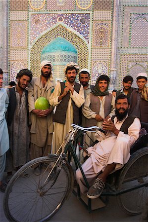 disabled asian people - Handicapped man sitting in special modified bike surrounded by men outside Shrine of Hazrat Ali, Mazar-I-Sharif, Balkh province, Afghanistan, Asia Foto de stock - Con derechos protegidos, Código: 841-02916821