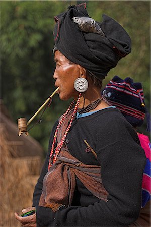 Aku lady with baby on her back smoking wooden pipe, Wan Sai village, Kengtung (Kyaing Tong), Shan state, Myanmar (Burma), Asia Stock Photo - Rights-Managed, Code: 841-02916908