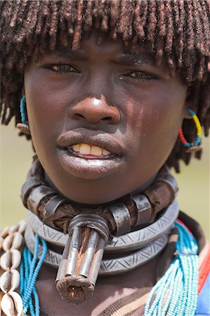 Banna woman wearing a necklace known as a bignere, a metal band with a phallic protuberance to signify she is a first wife, at the weekly market, Key Afir, Lower Omo Valley, Ethiopia, Africa Stock Photo - Rights-Managed, Code: 841-02917037