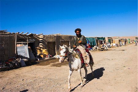 Man riding horse along road in small village, between Herat and Maimana, after Bala Murghah, Afghanistan, Asia Fotografie stock - Rights-Managed, Codice: 841-02917103