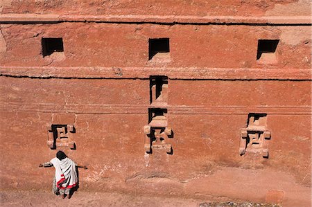 Pilgrim with arms outstreched standing under windows on monolithic church of Bet Maryam church (St. Mary's), believed to be the oldest rock hewn church in Lalibela, UNESCO World Heritage Site, Ethiopia, Africa Foto de stock - Con derechos protegidos, Código: 841-02917233