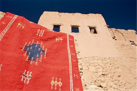 Red carpet drying in the sun, with mud house behind, Kasbah Ait Benhaddou, near Ouarzazate, Morocco, North Africa, Africa Stock Photo - Rights-Managed, Code: 841-02918016