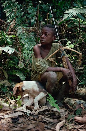 Young boy sitting in jungle with dog and wooden crossbow, southeast area, Cameroon, West Africa, Africa Stock Photo - Rights-Managed, Code: 841-02918800