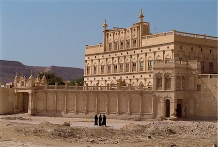 Women in black passing the house of a trader made rich from work in the Far East, Tarim, in the Wadi Hadramaut, south Yemen, Middle East Stock Photo - Rights-Managed, Code: 841-02920286