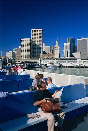 san francisco people - Man reading newspaper and passengers on the commuter ferry, with Ferry Building and skyline of downtown San Francisco in the background, California, United States of America, North America Stock Photo - Rights-Managed, Code: 841-02920421