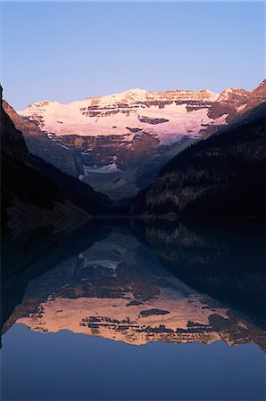 View to Mount Victoria across the still waters of Lake Louise, at sunrise in summer, Banff National Park, UNESCO World Heritage Site, Alberta, Canada, North America Foto de stock - Con derechos protegidos, Código: 841-02920666