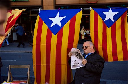 Reading the newspaper under the Catalan flag on La Rambla, Barcelona, Catalonia, Spain, Europe Foto de stock - Direito Controlado, Número: 841-02923997