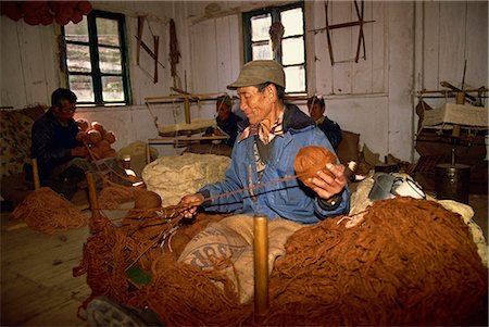 Portrait of a Tibetan man spinning wool in a carpet factory at a self-help centre in Darjeeling, India, Asia Stock Photo - Rights-Managed, Code: 841-02946990