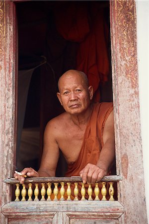 Head and shoulders portrait of an elderly Buddhist monk sitting at a window in Luang Prabang, Laos, Indochina, Southeast Asia, Asia Stock Photo - Rights-Managed, Code: 841-02947116
