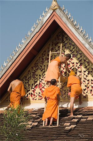 Monks on roof painting the temple decorations, Wat Mai, Luang Prabang, Laos, Indochina, Southeast Asia, Asia Foto de stock - Direito Controlado, Número: 841-03028538
