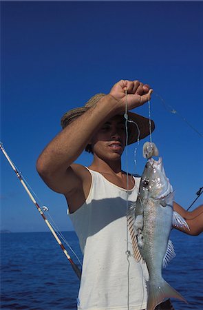 praslin island - Young man with fish caught on a line, northeast coast, island of Praslin, Seychelles, Indian Ocean, Africa Foto de stock - Direito Controlado, Número: 841-03034054