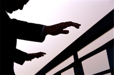 silhouette hand grasp - A business man outdoors with outstretched hands about to grasp railings Stock Photo - Rights-Managed, Code: 841-03034647