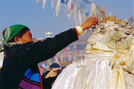 simsearch:841-02917363,k - Buddhist woman putting incense sticks in flour pot (the flour represents Buddha's spirit) during the Losar (Tibetan New Year), Bodhnath, Katmandu, Nepal Stock Photo - Rights-Managed, Code: 841-03033490