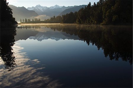 Lake Matheson in the evening reflecting a near perfect image of Mount Tasman and Aoraki (Mount Cook), 3754m, Australasia's highest mountain, South Island, New Zealand, Pacific Foto de stock - Con derechos protegidos, Código: 841-03055123