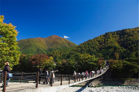 shirakawago - Suspension bridge with tourists looking at autumn colours in the UNESCO World Heritage Site of Gassho Zukkuri (Thatched Gable Roof Houses), Shirakawago District, Ogi Town, Gifu Prefecture, Honshu Island, Japan, Asia Stock Photo - Rights-Managed, Code: 841-03055615