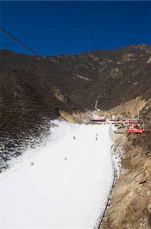 skiers and chairs lifts in snow - A ski lift taking skiers up to the slopes at Shijinglong ski resort, Beijing, China, Asia Stock Photo - Rights-Managed, Code: 841-03055952