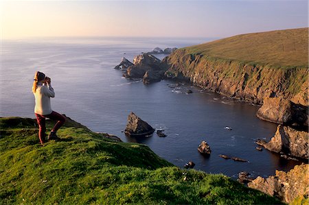 Birdwatching on cliffs of Hermaness Nature Reserve, looking north towards Vesta Skerry, Tipta Skerry gannetry, Muckle Flugga and its lighthouse in the distance, Unst, Shetland Islands, Scotland, United Kingdom, Europe Stock Photo - Rights-Managed, Code: 841-03064349