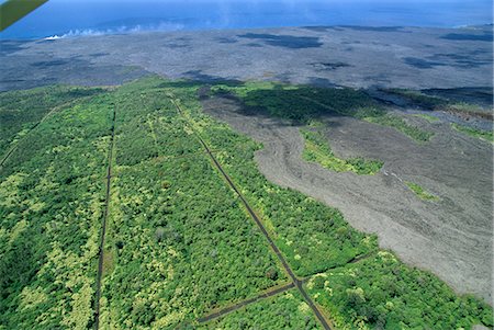 Aerial view of basalt lava flows on the southern flank of the Kilauea volcano, the lava now flows underground for miles in tubes to the sea, where steam is visible on the coast, Big Island, Hawaii, Hawaiian Islands, United States of America (U.S.A.), North America Stock Photo - Rights-Managed, Code: 841-03067355