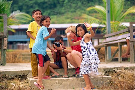 simsearch:841-02902571,k - A group of Iban Dayak children with a tourist and camera outside their longhouse on the Rajang River near Kapit in Sarawak, northwest Borneo, Malaysia, Southeast Asia, Asia Fotografie stock - Rights-Managed, Codice: 841-03067649