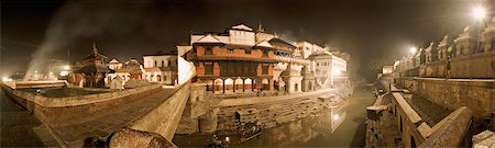 simsearch:841-03672874,k - Smoke from funeral pyres on the ghats on the left drifts across the bridge over the river Bagmati at Nepal's holiest Hindu pilgrimage site, Pashupatinath, Kathmandu, Nepal, Asia Foto de stock - Con derechos protegidos, Código: 841-03490114