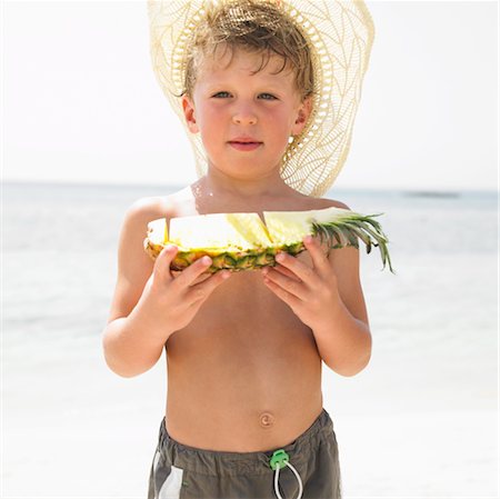 simsearch:841-03507749,k - Boy (6-8) on beach holding slice of pineapple Stock Photo - Rights-Managed, Code: 841-03507736