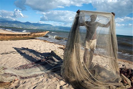 A fisherman tends his nets on Plage des Cocotiers (Coconut Beach) also known as Saga Beach, Lake Tanganyika, Bujumbura, Burundi, East Africa, Africa Foto de stock - Con derechos protegidos, Código: 841-03507948