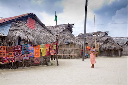 Molas hanging up for sale outside thatched houses, Isla Tigre, San Blas Islands, Comarca de Kuna Yala, Panama, Central America Stock Photo - Rights-Managed, Code: 841-03517047