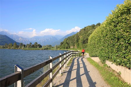 riding bicycle sea - Man bikes along path at lake's edge, Lake Como, Italian Lakes, Lombardy, Italy, Europe Stock Photo - Rights-Managed, Code: 841-03518816