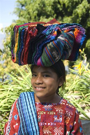 Indigenous girl carrying textiles for sale on her head, Lake Atitlan, Guatemala, Central America Fotografie stock - Rights-Managed, Codice: 841-03675343