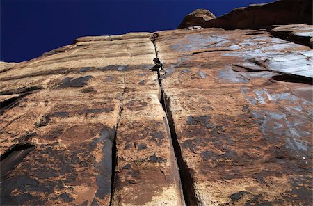 A rock climber tackles an overhanging crack in a sandstone wall on the cliffs of Indian Creek, a famous rock climbing area in Canyonlands National Park, near Moab, Utah, United States of America, North America Stock Photo - Rights-Managed, Code: 841-03675354