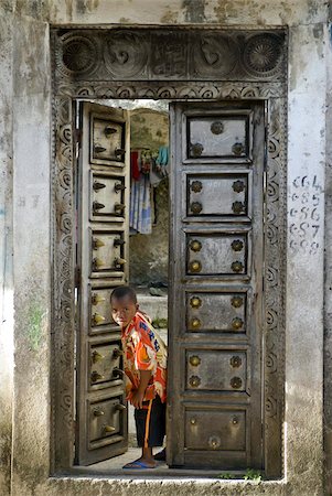 Young boy curiously looking through an old antique door, Moroni, Grand Comore, Comores, Indian Ocean, Africa Stock Photo - Rights-Managed, Code: 841-03676539