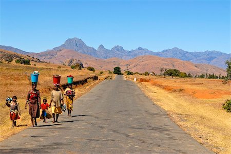 People walking along a street in the background Pic Bobby (Pic d'Imarivolanitra) in the Andringitra National Park, Madagascar, Africa Foto de stock - Con derechos protegidos, Código: 841-03676770