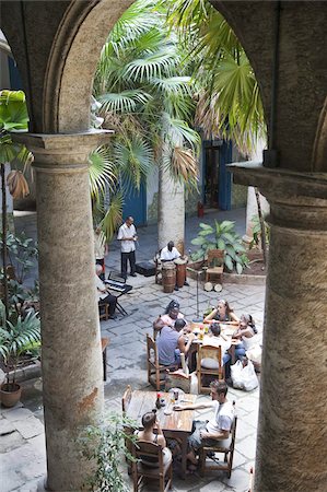 People sitting at tables and musicians playing in courtyard of colonial building built in 1780, Havana, Cuba, West Indies, Central America Stock Photo - Rights-Managed, Code: 841-03677186