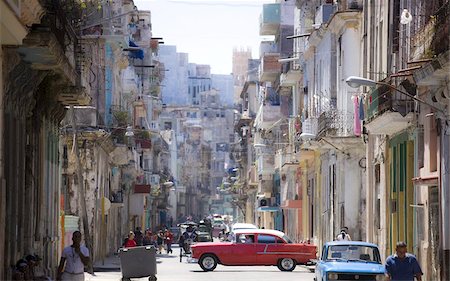 View along congested street in Havana Centro showing people walking along pavements, traffic on the road and a red American car crossing intersection, Havana, Cuba, West Indies, Central America Stock Photo - Rights-Managed, Code: 841-03672436