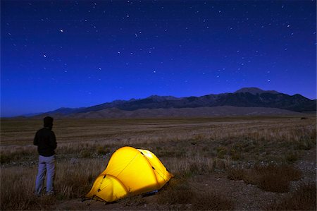 star (astronomy) - Hiker and tent illuminated under the night sky, Great Sand Dunes National Park, Colorado, United States of America, North America Stock Photo - Rights-Managed, Code: 841-03868516