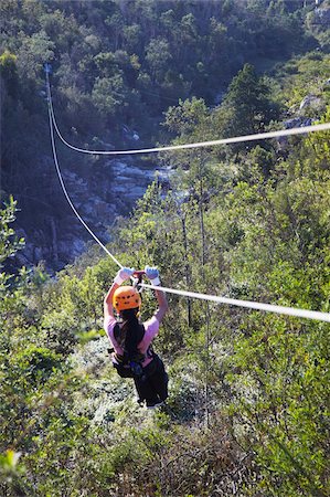 Woman sliding down a zip-line, Storms River, Eastern Cape, South Africa, Africa Foto de stock - Direito Controlado, Número: 841-03870170