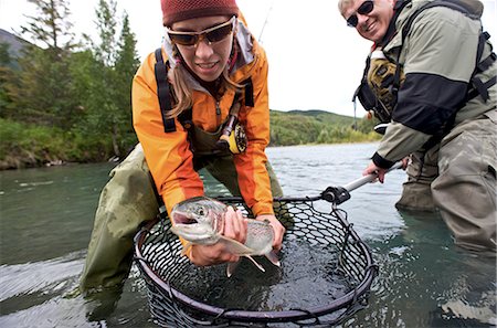 people catching fishes - Man and Woman hold a rainbow trout caught while fly fishing on the upper Kenai River on the Kenai Peninsula of Southcentral Alaska during Fall Stock Photo - Rights-Managed, Code: 854-02954999