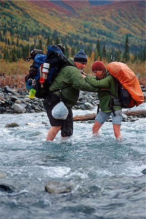 Pair of backpackers ford the Kotsina River at Wrangell-St.Elias National Park in Southcentral Alaska. Stock Photo - Rights-Managed, Code: 854-02955230