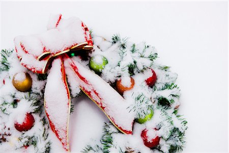 Close up of a snowcovered Christmas wreath with a red bow lying in the snow in Fairbanks, Alaska Foto de stock - Con derechos protegidos, Código: 854-02955843