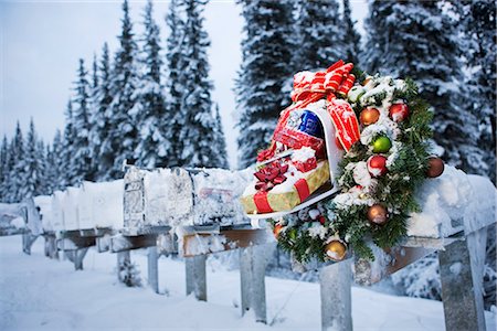 Several mailboxes lined up in a row with one decorated with a Christmas wreath during winter in Alaska Foto de stock - Con derechos protegidos, Código: 854-02955853