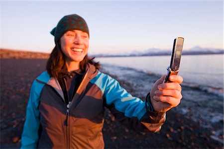 spit - Femme utilise son téléphone cellulaire pour photographier le coucher de soleil sur le golfe de Cook sur l'isthme de Homer, Alaska Photographie de stock - Rights-Managed, Code: 854-02955930