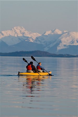 Sea Kayakers paddle the shoreline on a calm evening in Favorite Passage near Juneau, Alaska with Eagle Peak & Admiralty Island in the background Stock Photo - Rights-Managed, Code: 854-03361803