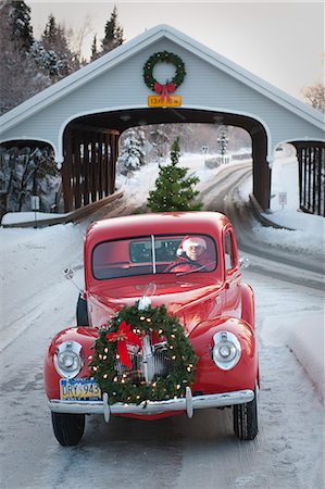 ford - Homme conduisant un pick-up Ford de vintage 1941 grâce à un pont couvert avec une guirlande de Noël sur le grill et un arbre dans le dos pendant l'hiver dans le centre-sud, Alaska Photographie de stock - Rights-Managed, Code: 854-03362342