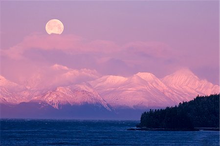 pleine lune - La pleine lune se couche sur les montagnes de Chilkat et Lynn Canal au lever du soleil surplombant Lynn Canal, Passage de l'intérieur, de l'Alaska Photographie de stock - Rights-Managed, Code: 854-03362435