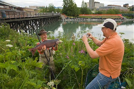 spin fishing - Fisherman poses with King Salmon at Ship Creek in downtown Anchorage, Alaska during Summer Stock Photo - Rights-Managed, Code: 854-03538040